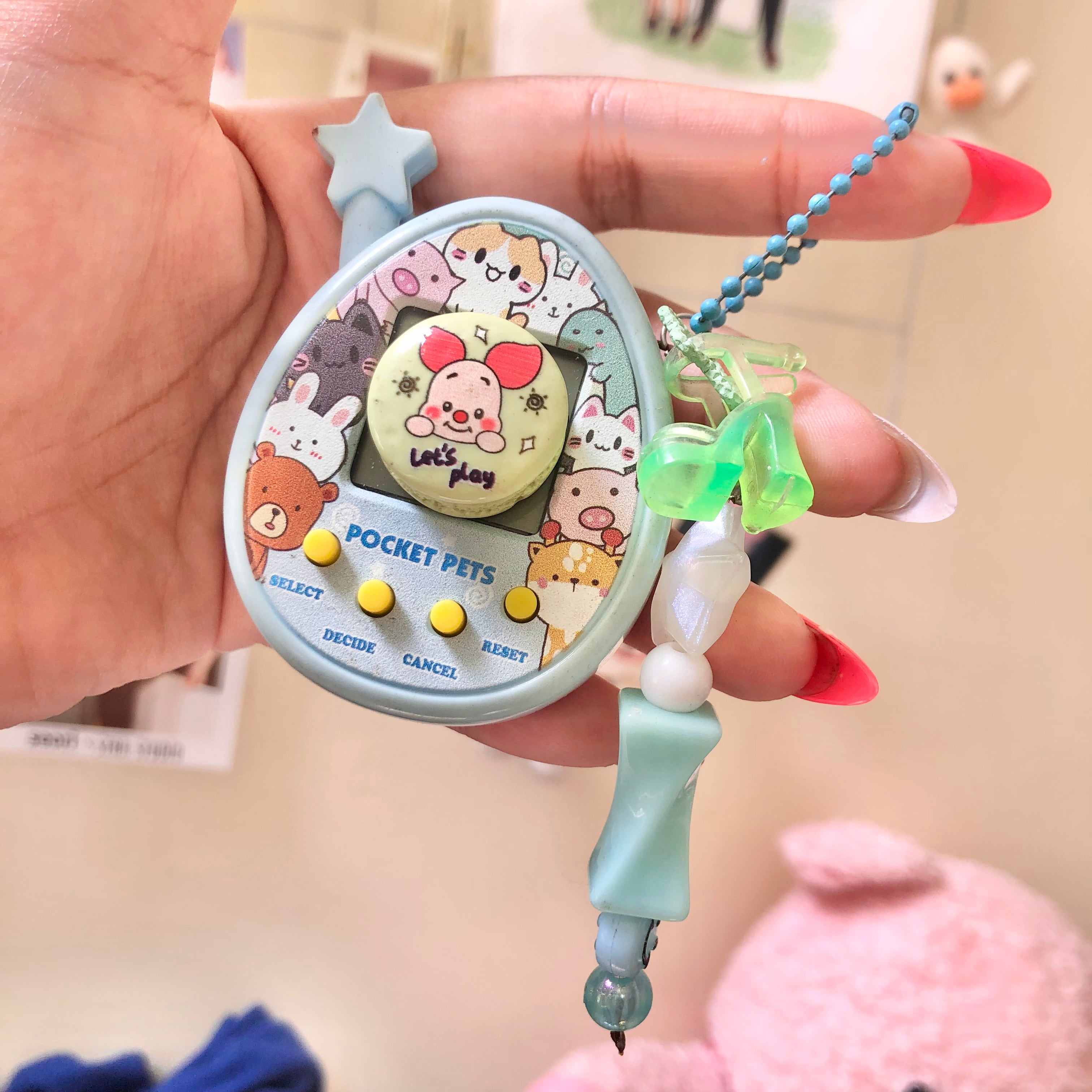 Pocket Pets virtual pet toy front view with macaron charm and star charm