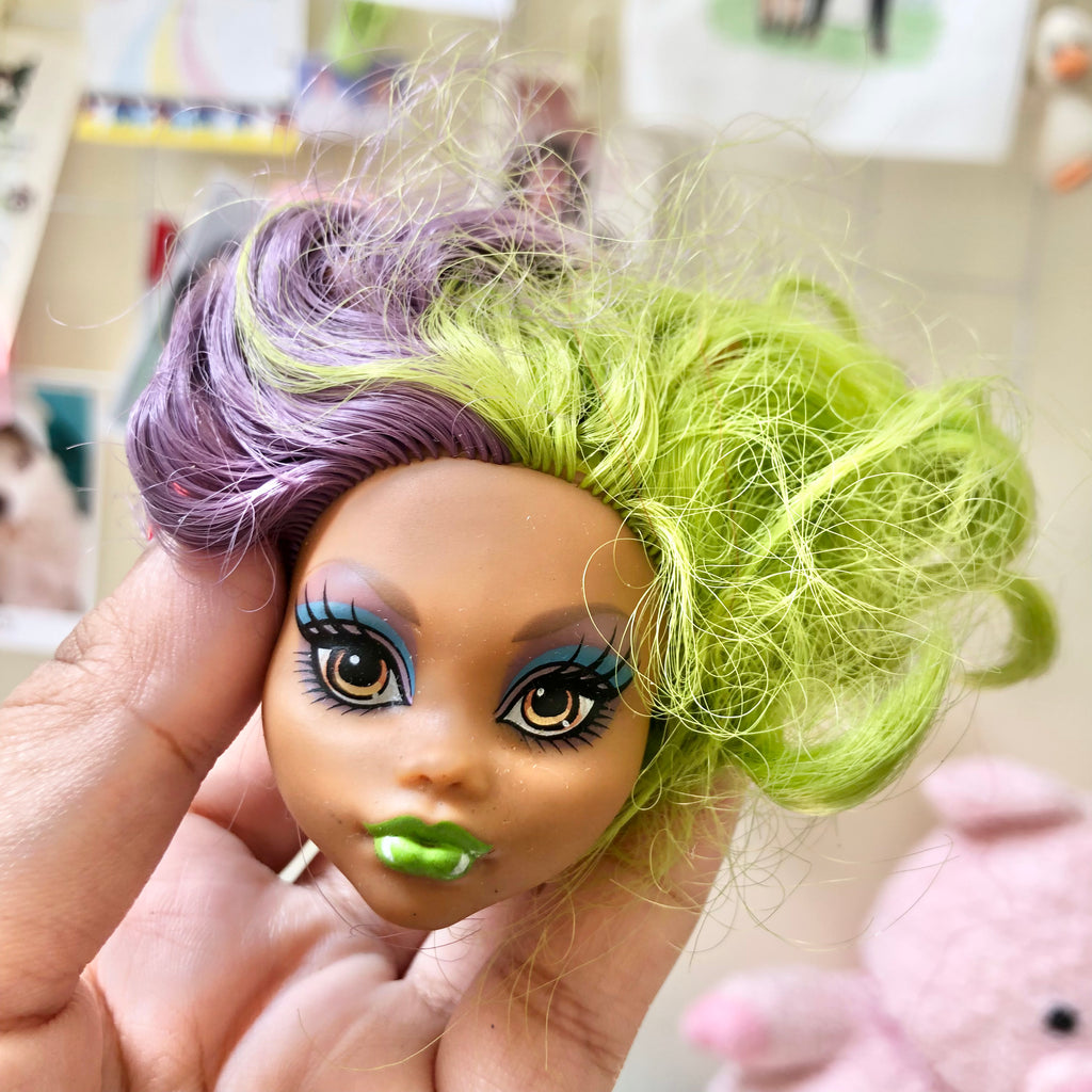 Side view of customized doll head showing purple hair