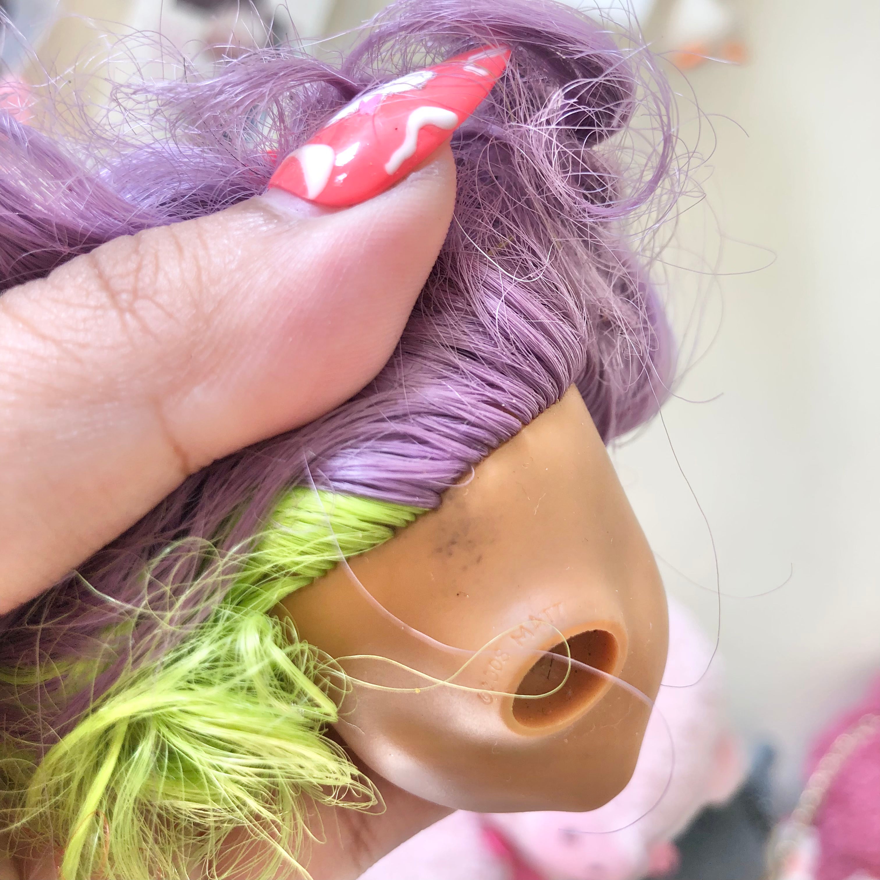 Front view of customized doll head with purple and lime green hair